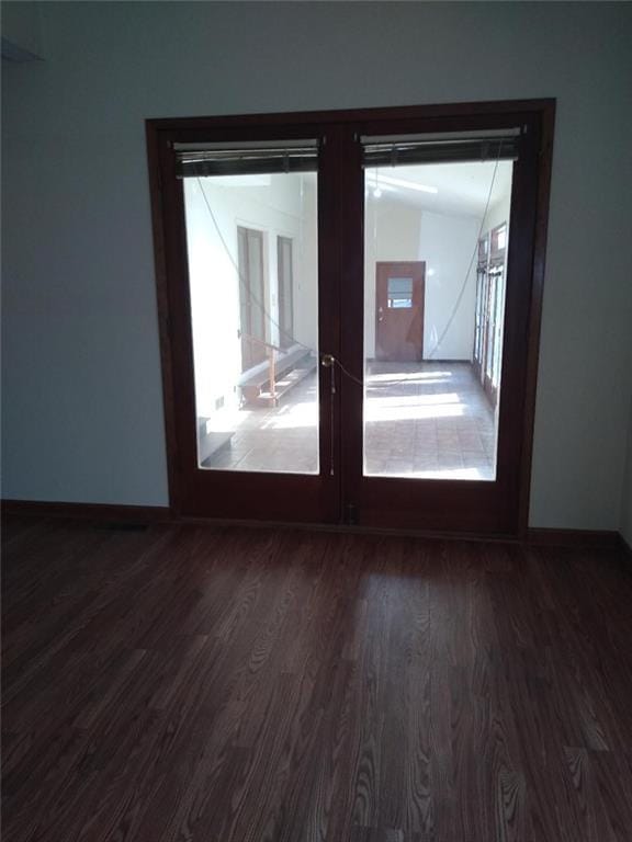 unfurnished room with french doors and dark wood-type flooring