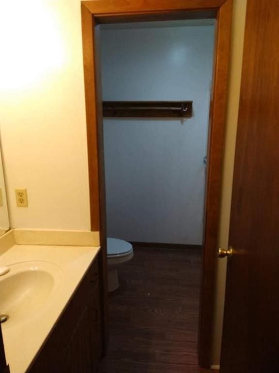 bathroom with hardwood / wood-style flooring, toilet, and vanity