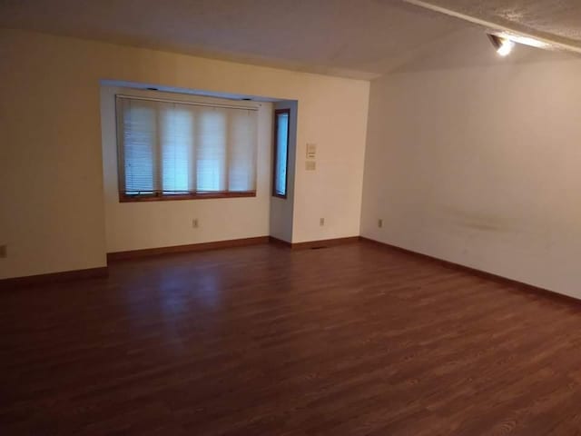 unfurnished room with dark wood-type flooring