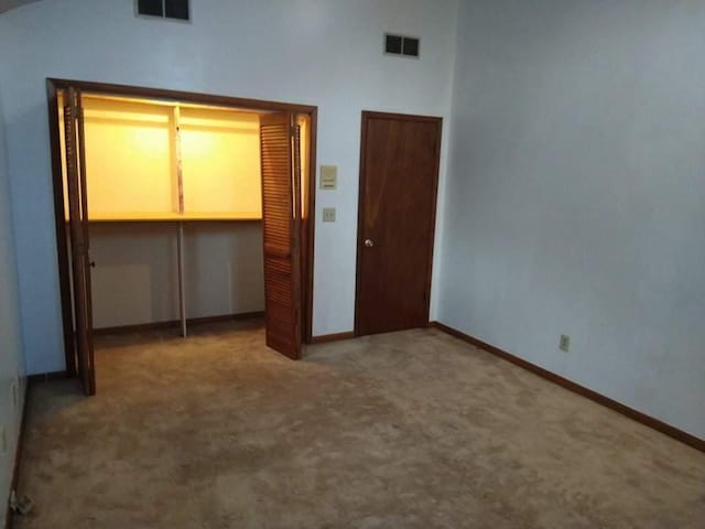 unfurnished bedroom featuring a closet, dark colored carpet, and lofted ceiling