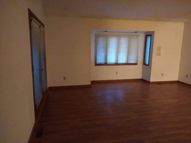 unfurnished room with dark hardwood / wood-style flooring