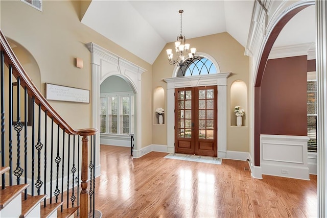 entrance foyer with stairs, an inviting chandelier, visible vents, and light wood-style floors