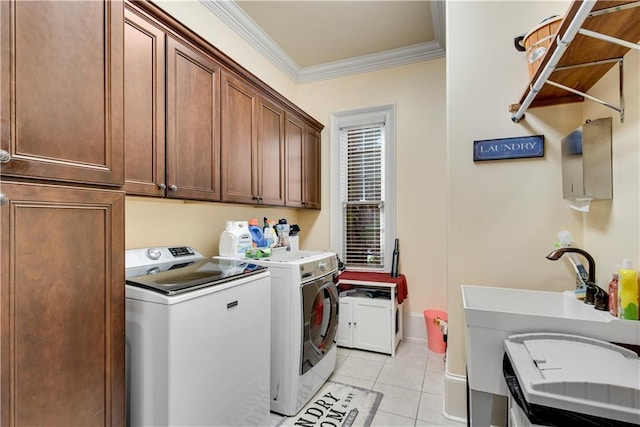 washroom with light tile patterned flooring, washing machine and dryer, baseboards, ornamental molding, and cabinet space