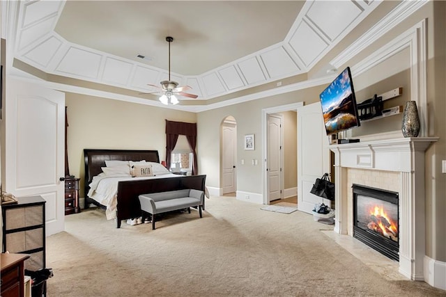 bedroom featuring carpet, visible vents, arched walkways, and a tiled fireplace