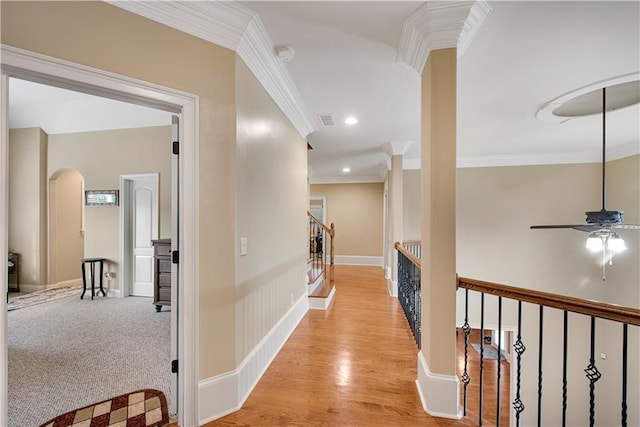 corridor with visible vents, stairway, ornamental molding, light wood-type flooring, and baseboards