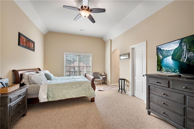 bedroom featuring light carpet, baseboards, visible vents, arched walkways, and lofted ceiling