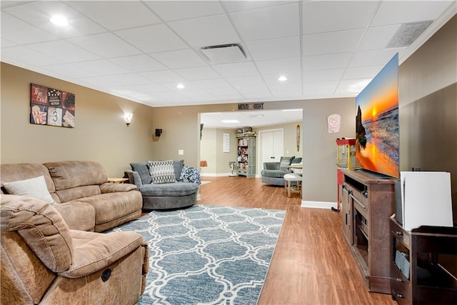 living area featuring recessed lighting, a paneled ceiling, visible vents, wood finished floors, and baseboards