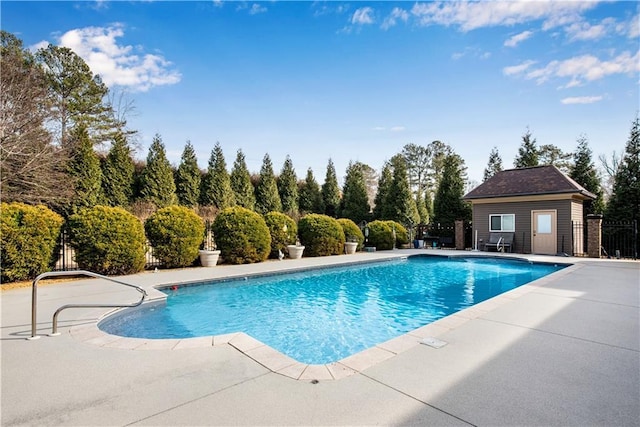 view of swimming pool featuring a fenced in pool, fence, an outdoor structure, and a patio