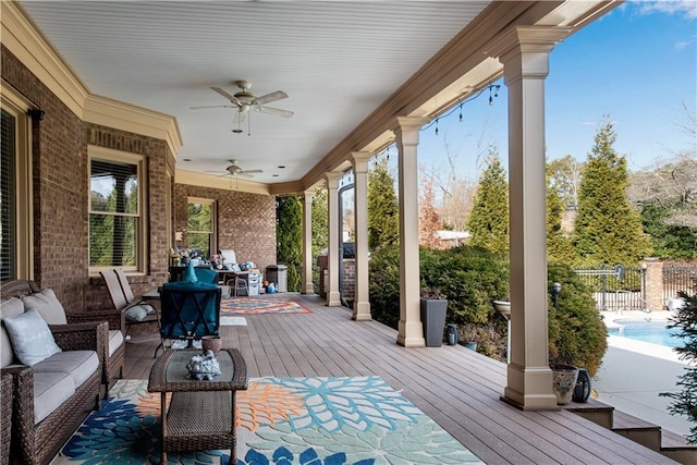 deck with outdoor lounge area, fence, and ceiling fan