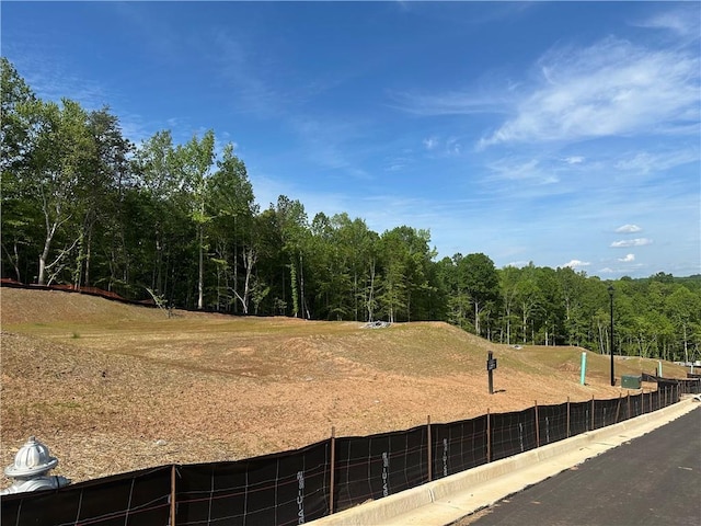exterior space featuring fence and a view of trees