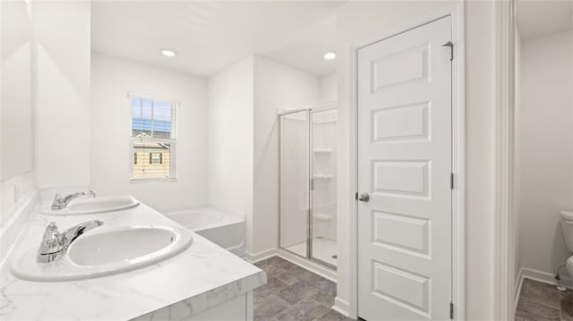 bathroom featuring a sink, toilet, and a stall shower