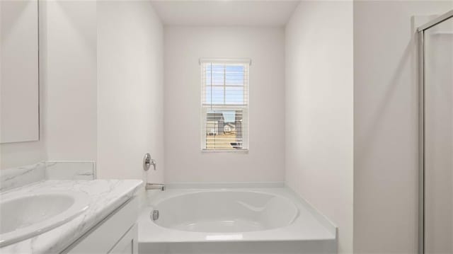 full bath with vanity, a garden tub, and a shower stall