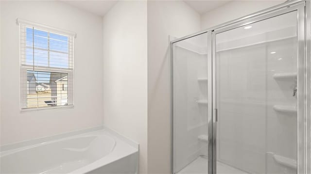 full bath with a stall shower, a wealth of natural light, and a garden tub