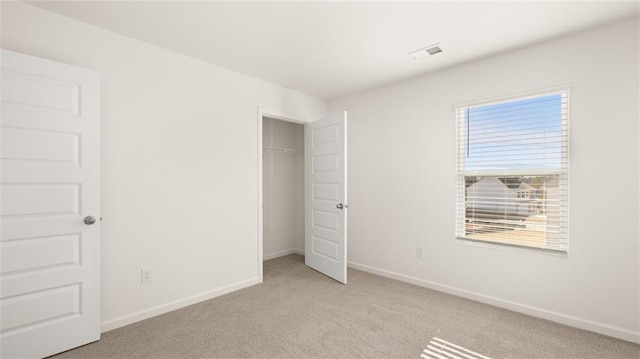 unfurnished bedroom with baseboards, visible vents, and light carpet
