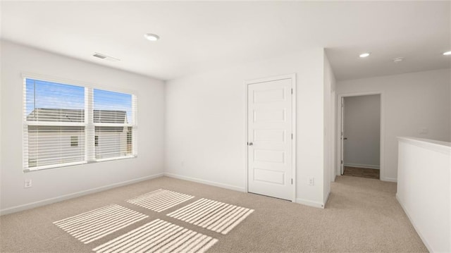 unfurnished bedroom featuring baseboards, visible vents, recessed lighting, and carpet
