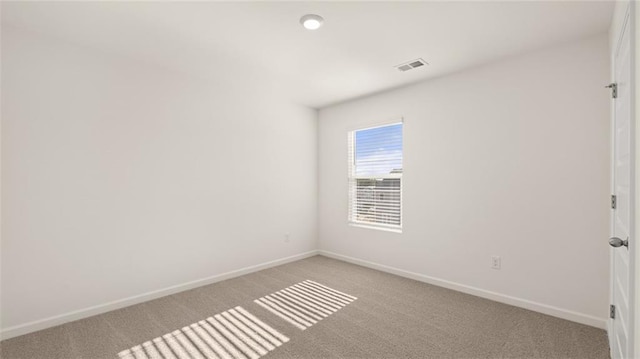 spare room featuring baseboards, visible vents, and light colored carpet