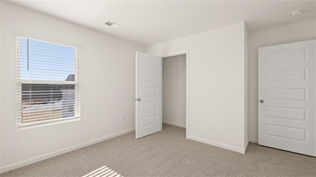 unfurnished bedroom with baseboards, visible vents, a closet, and carpet