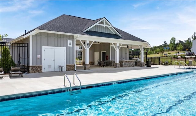 pool with an exterior structure, a ceiling fan, an outbuilding, fence, and a patio