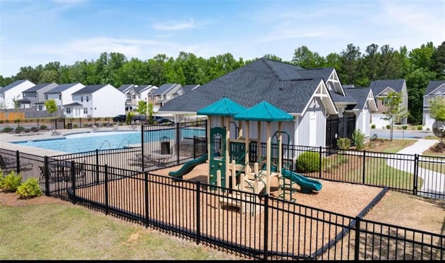 community play area with a residential view, fence, and a community pool