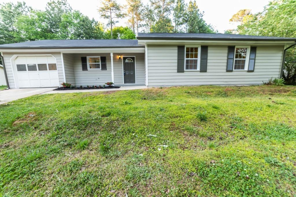 ranch-style home featuring a front lawn, an attached garage, and concrete driveway