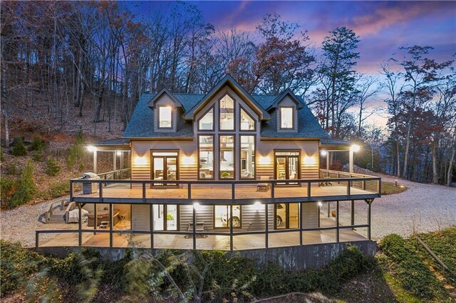 back house at dusk with a deck and french doors