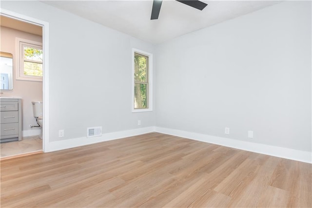 empty room with plenty of natural light, light hardwood / wood-style floors, and ceiling fan