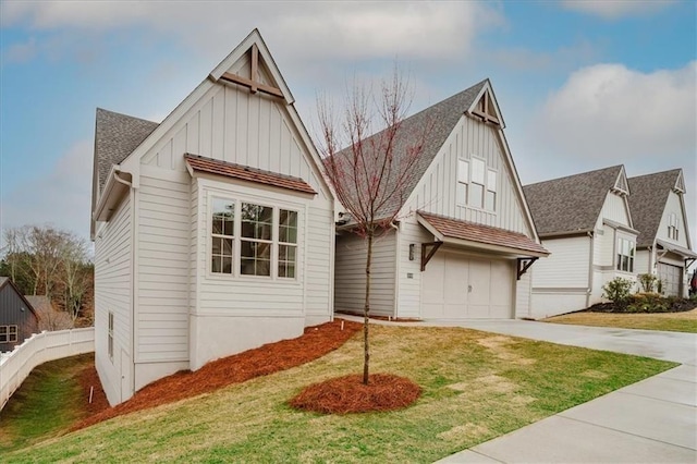 view of front facade featuring roof with shingles, board and batten siding, and a front yard