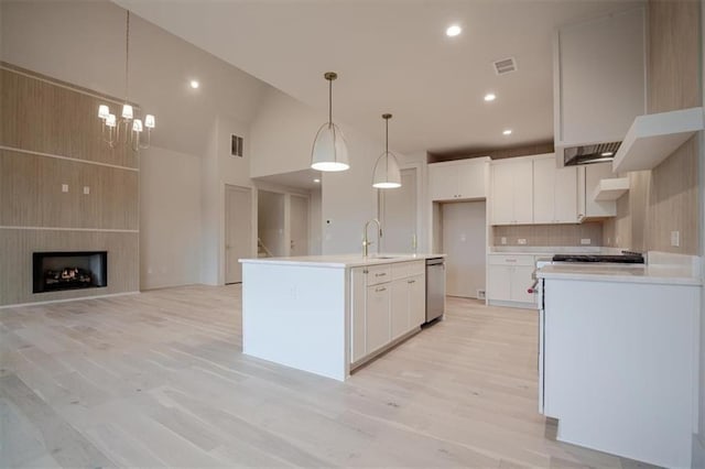 kitchen with a sink, visible vents, light countertops, and light wood-style floors