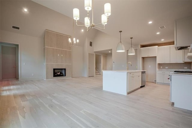 kitchen featuring visible vents, white cabinets, an inviting chandelier, dishwasher, and light wood-style flooring