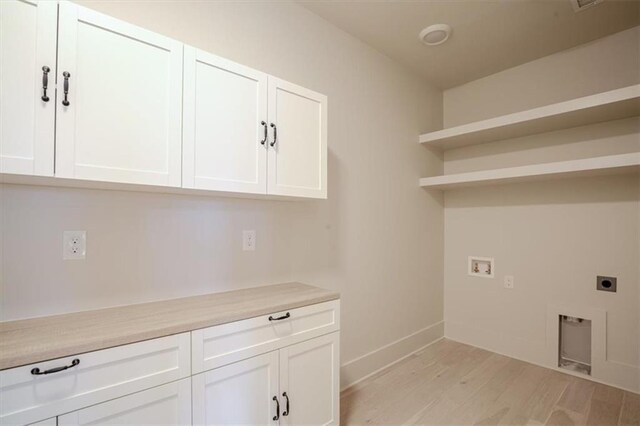 laundry area featuring baseboards, washer hookup, hookup for an electric dryer, cabinet space, and light wood-style flooring
