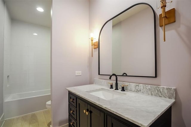 bathroom with toilet, recessed lighting, vanity, and wood finished floors