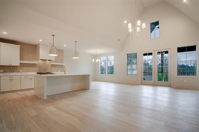 kitchen featuring light countertops, light wood finished floors, a notable chandelier, and decorative backsplash