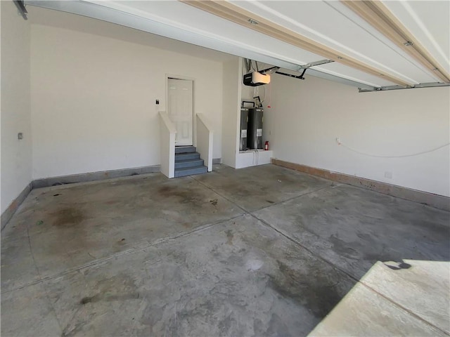 garage featuring baseboards, electric water heater, and a garage door opener