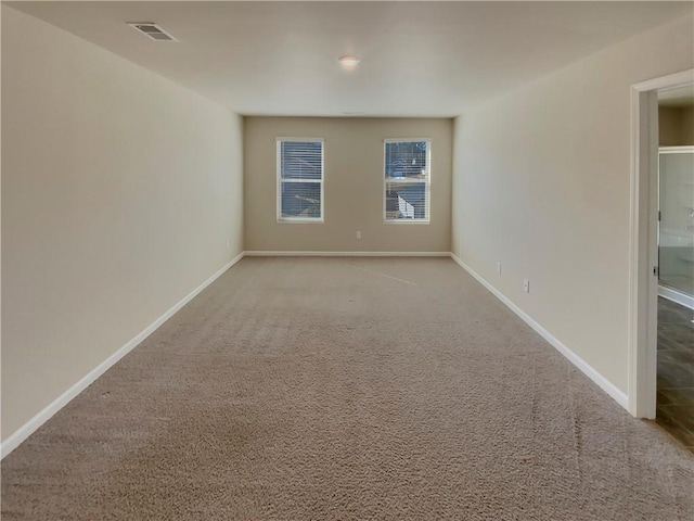 spare room with baseboards, visible vents, and carpet flooring