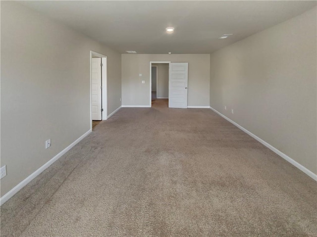 unfurnished room with carpet and baseboards