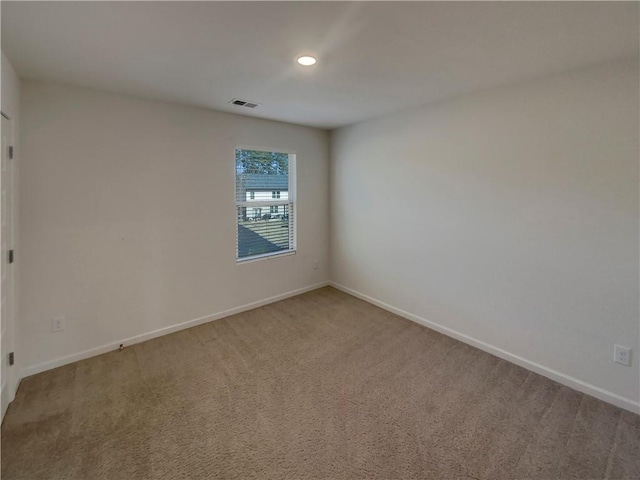 spare room with carpet floors, recessed lighting, visible vents, and baseboards