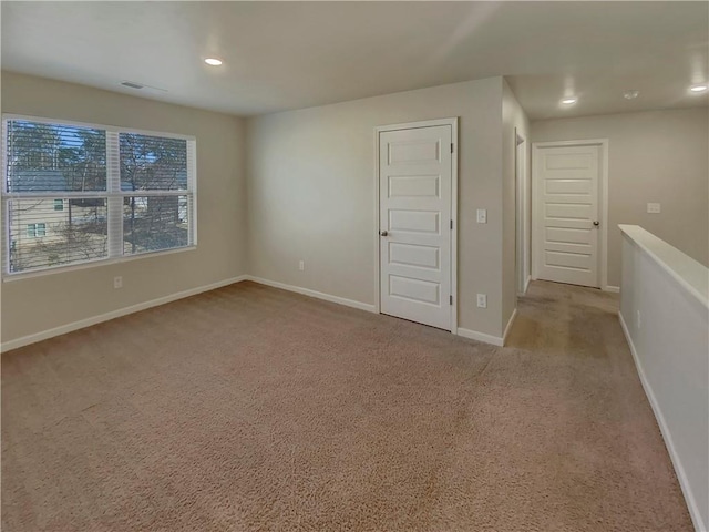 carpeted spare room with recessed lighting, visible vents, and baseboards