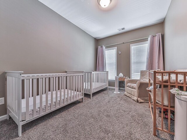 carpeted bedroom featuring a crib