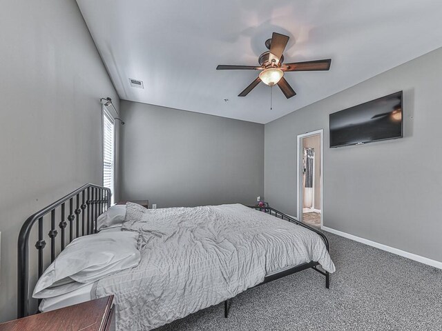 carpeted bedroom featuring ceiling fan and ensuite bath