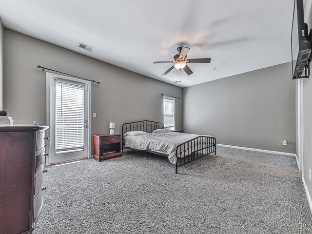 carpeted bedroom with multiple windows and ceiling fan