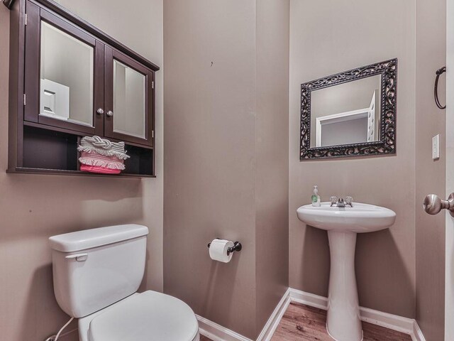 bathroom featuring hardwood / wood-style flooring and toilet