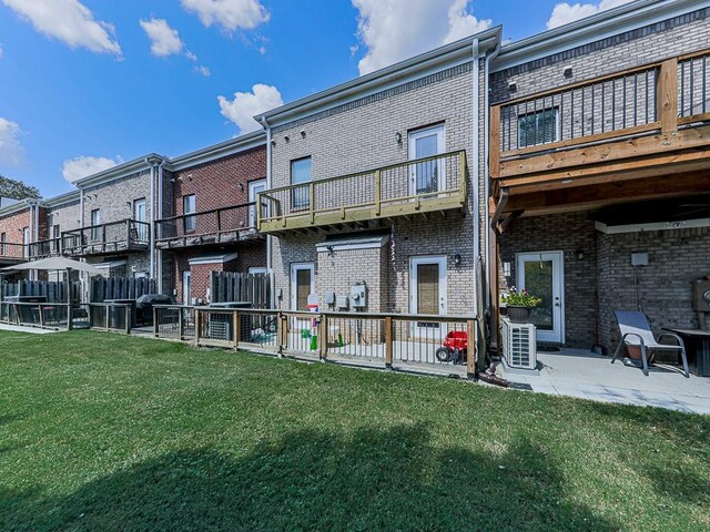 back of house featuring a balcony, a yard, central AC, and a patio area