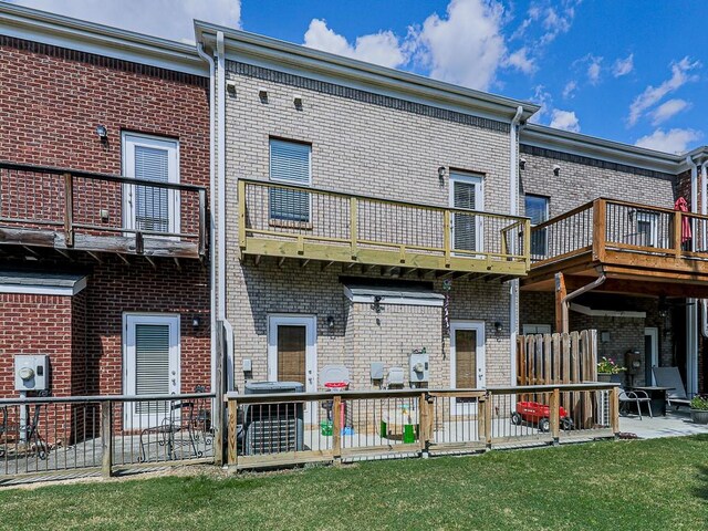 back of house with a balcony, a yard, and a patio area