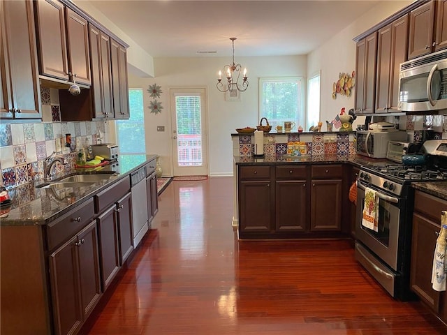 3692 Archgate Ct, Alpharetta, GA 30004 - kitchen with stainless steel appliances, a peninsula, a sink, backsplash, and dark stone countertops