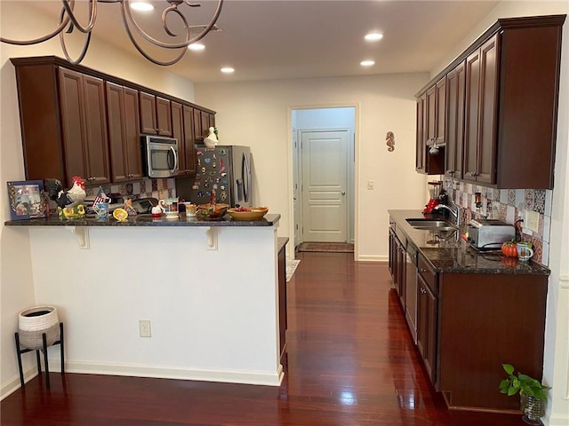 3692 Archgate Ct, Alpharetta, GA 30004 - kitchen featuring stainless steel appliances, a sink, dark wood-style floors, a kitchen bar, and recessed lighting