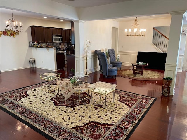 3692 Archgate Ct, Alpharetta, GA 30004 - living room featuring a chandelier, wood finished floors, a wainscoted wall, stairs, and decorative columns