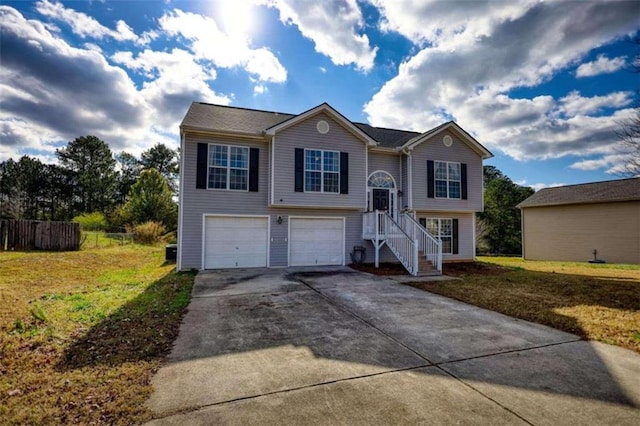 raised ranch featuring a garage and a front lawn