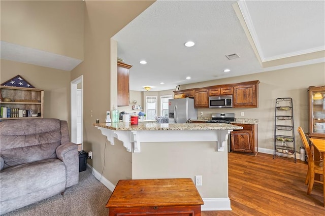 108 Lake Point Ct, Jefferson, GA 30549 - kitchen with appliances with stainless steel finishes, a breakfast bar area, a peninsula, open floor plan, and light stone countertops