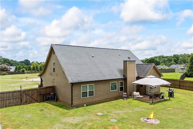 108 Lake Point Ct, Jefferson, GA 30549 - back of property with an outdoor fire pit, a fenced backyard, a chimney, a patio area, and roof with shingles