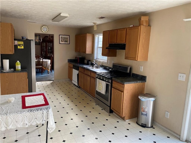 kitchen featuring stainless steel appliances, sink, and a textured ceiling